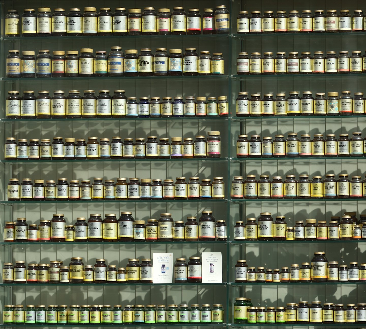 棚にたくさんのビタミン剤やサプリメントのボトルが並んでいます。